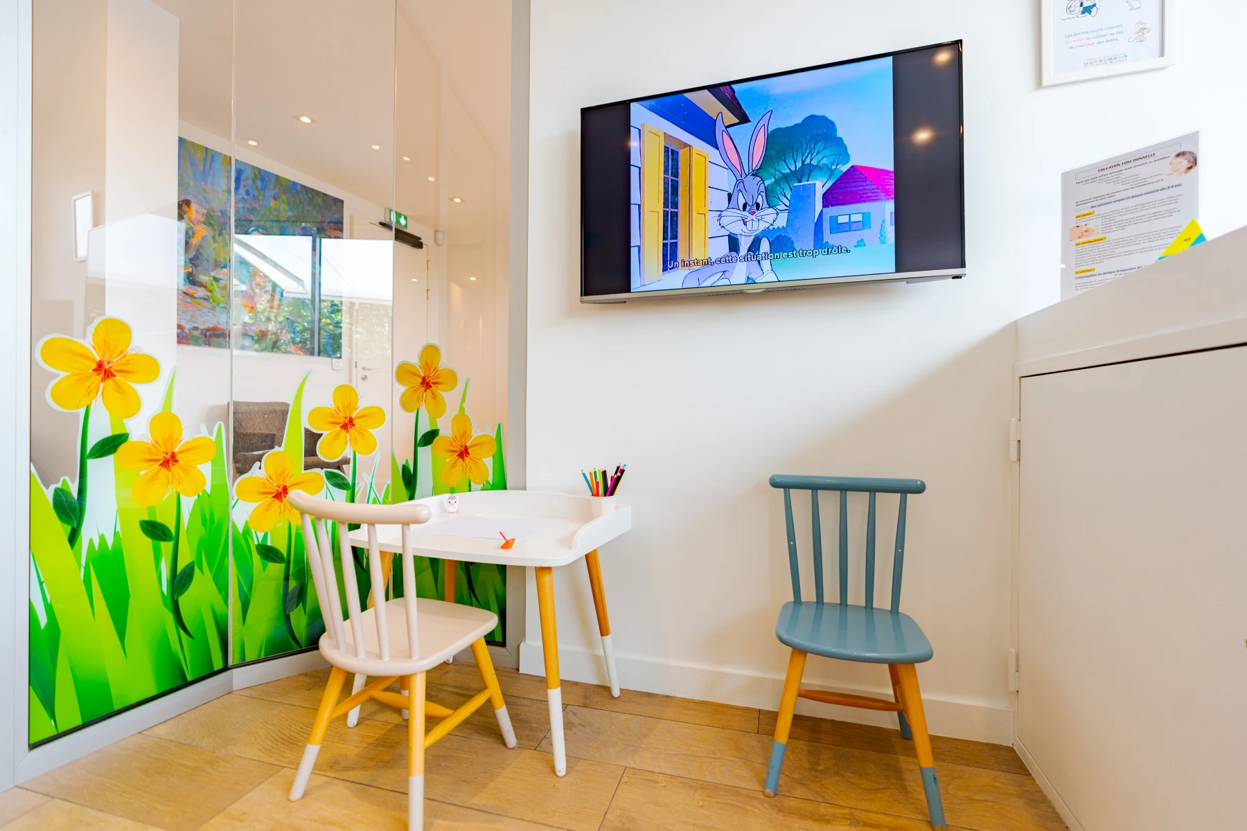 Coin enfants du cabinet dentaire Escudier, fresque de jonquilles, table et chaises