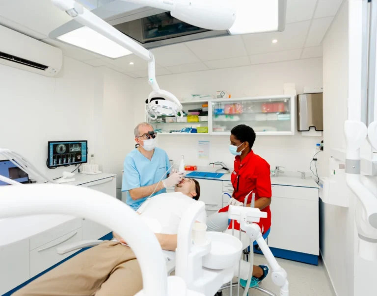 Consultation pour une réhabilitation globale sur implants, praticien et assistante au fauteuil