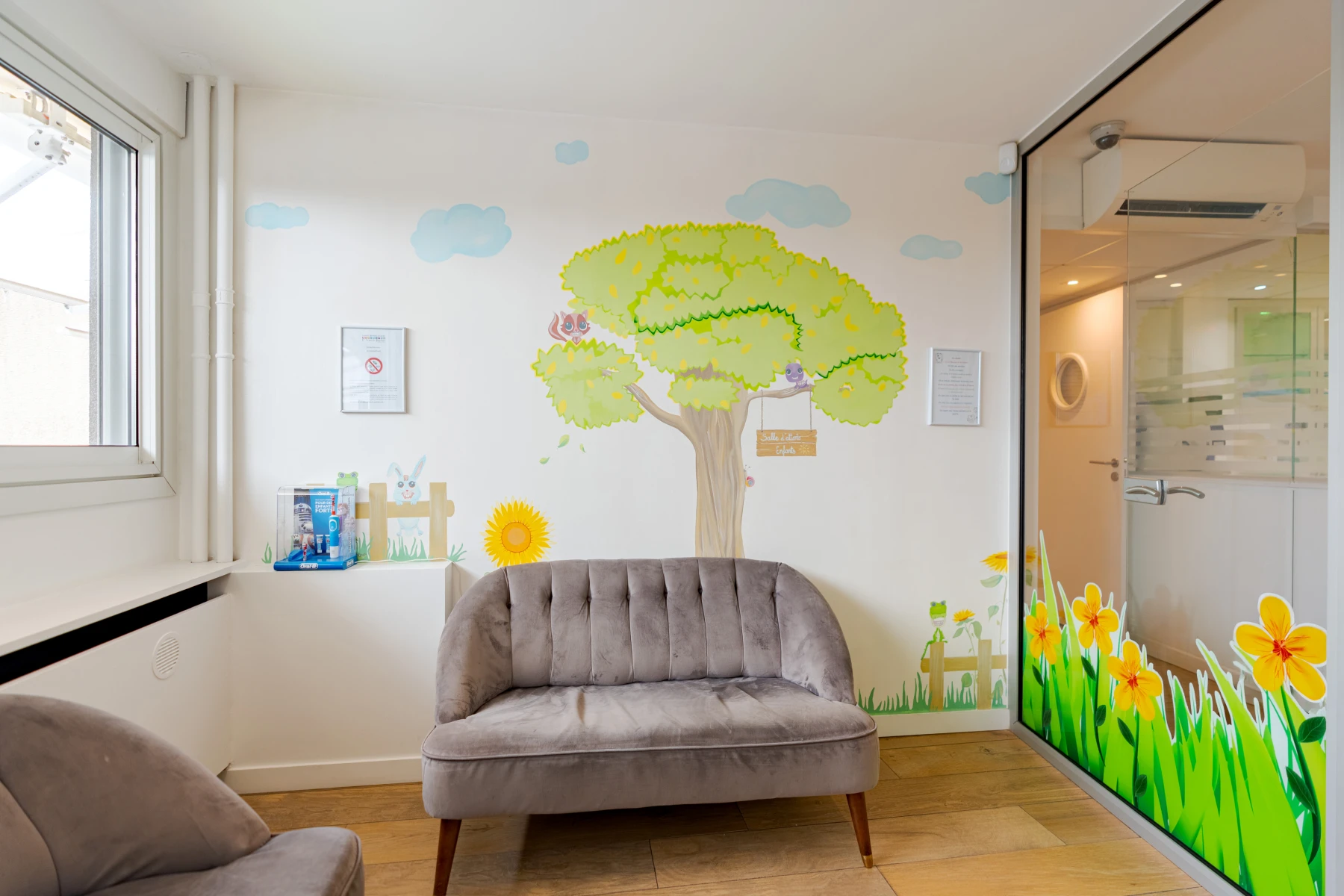 Salle d’attente du cabinet dentaire Escudier avec une fresque d’arbre