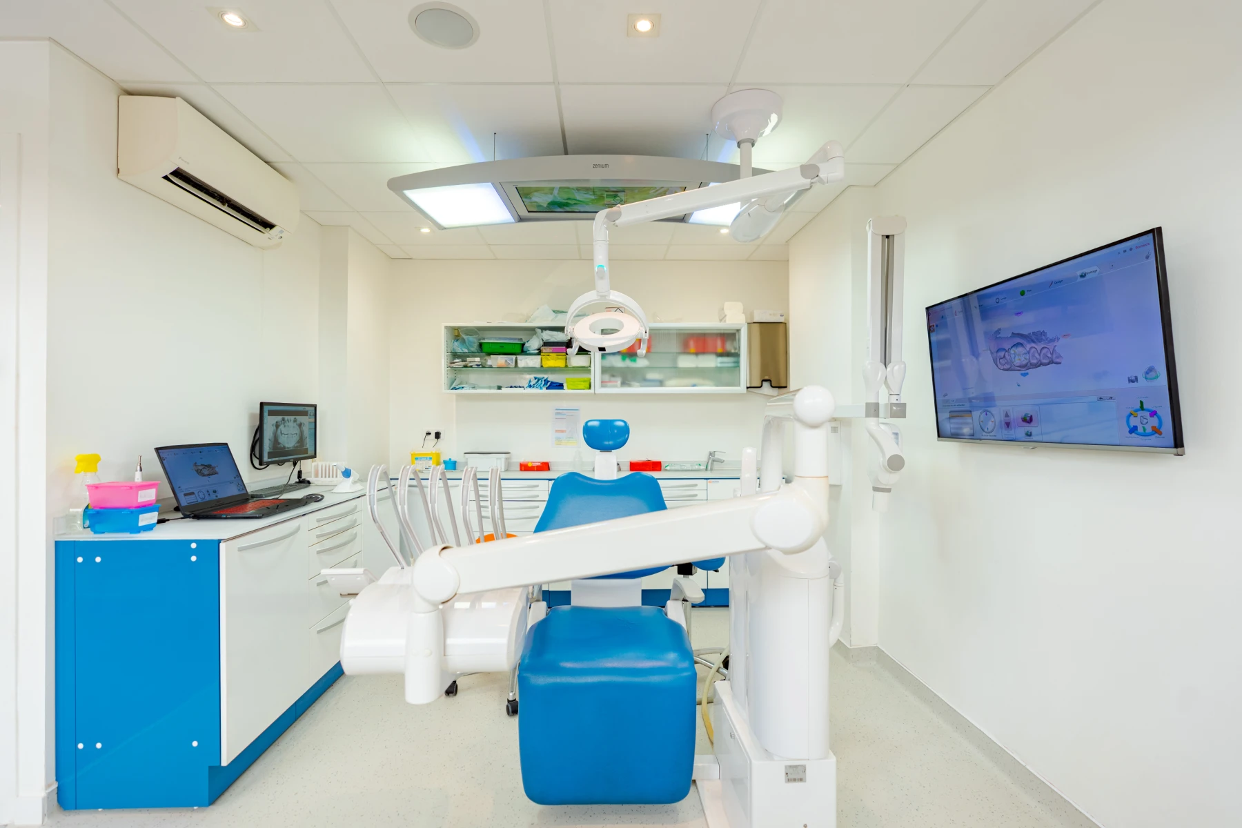 Salle de soins équipée du cabinet dentaire Escudier, écran et meubles bleus